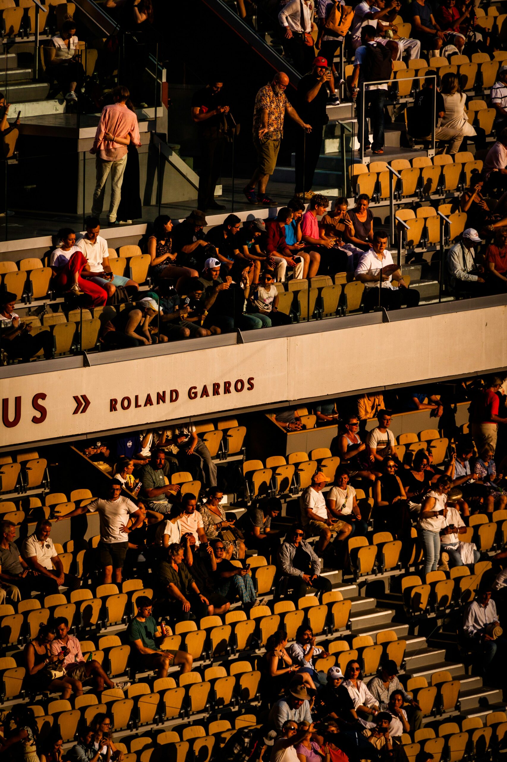 Spectators in the stands at Roland Garros with Roland Garros branding visible