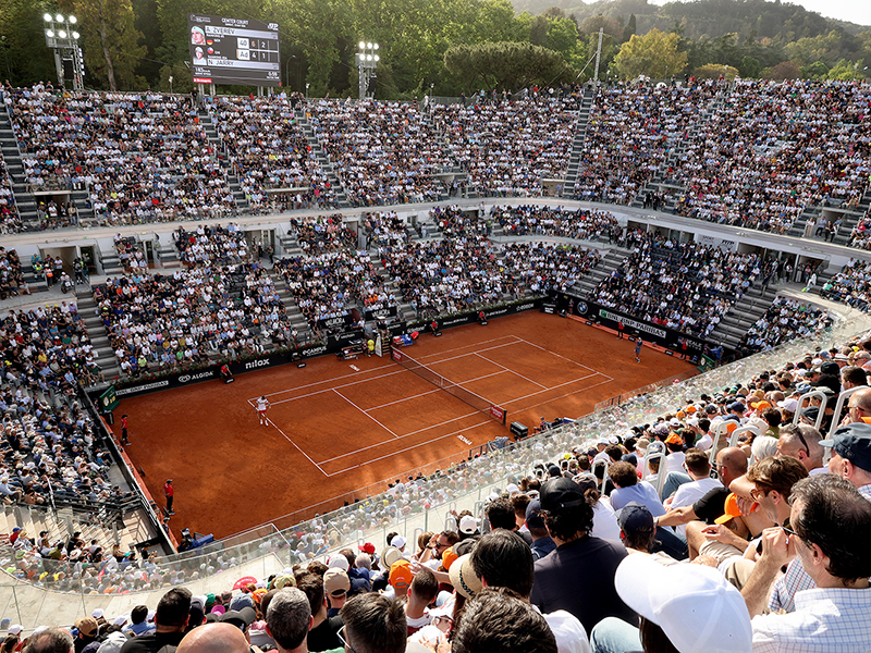 Un partido de la sesión diurna en el Campo Centrale del Abierto de Italia, ante un público que abarrotaba las gradas bajo la luz del sol.